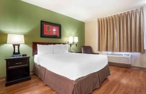 un grande letto in una camera d'albergo con copriletto bianco di Extended Stay America Select Suites - Baton Rouge - Citiplace a Baton Rouge