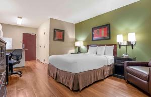 una camera d'albergo con un grande letto e una scrivania di Extended Stay America Select Suites - Baton Rouge - Citiplace a Baton Rouge