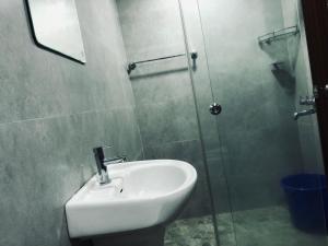 bagno con lavandino e doccia in vetro di Garuda Suites a Varkala