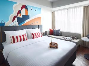 um quarto de hotel com uma cama grande e um sofá em Citadines Harbour Front Yokohama em Yokohama