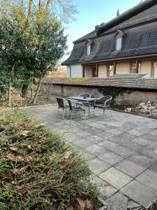 een patio met 2 stoelen en een tafel voor een huis bij Zimmer mit geteiltem Bad & Küche in Brugg