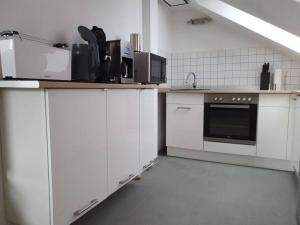 バート・デュレンベルクにあるFerienwohnung direkt am Kurpark Laga mit Gradierwerk Solestadtのキッチン(白いキャビネット、コンロ付)