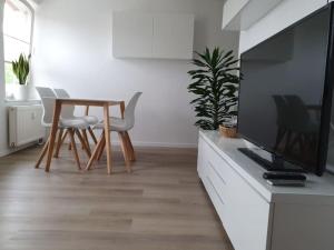 バート・デュレンベルクにあるFerienwohnung direkt am Kurpark Laga mit Gradierwerk Solestadtのリビングルーム(テーブル、薄型テレビ付)