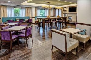 Hampton Inn Dumfries/Quantico في دومفريس: غرفة طعام مع طاولات وكراسي أرجوانية