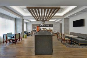 - un hall avec un bar, des tables et des chaises dans l'établissement Hampton Inn Peterborough, à Peterborough