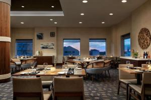 um restaurante com mesas, cadeiras e janelas em Hilton Suites Ocean City Oceanfront em Ocean City