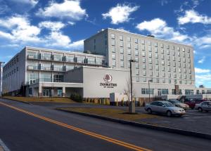 a large white building with cars parked in a parking lot at DoubleTree by Hilton Hotel Niagara Falls New York in Niagara Falls