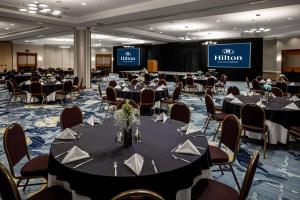 een vergaderzaal met tafels en stoelen en een podium bij Hilton Austin Airport in Austin