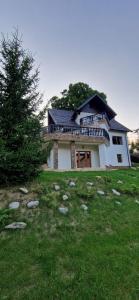 uma casa numa colina com uma árvore em frente em Chalet Poarta em Bran