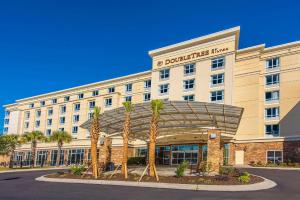 un hotel con palmeras frente a un edificio en DoubleTree by Hilton North Charleston - Convention Center, en Charleston