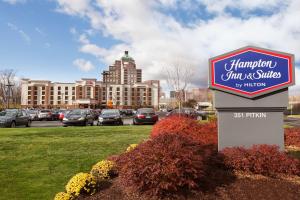 a sign for a hampton inn and suites in a parking lot at Hampton Inn & Suites East Hartford in East Hartford