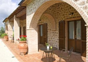 een patio met een tafel en stoelen in een bakstenen gebouw bij Agriturismo Le Cascatelle in Saturnia