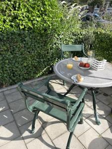 - une table et une chaise avec un bol de fruits dans l'établissement Noordwijk BB228, à Noordwijk