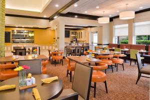 un ristorante con tavoli e sedie in una caffetteria di Hilton Garden Inn Indianapolis/Carmel a Carmel