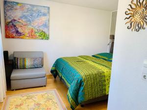 1 dormitorio con 1 cama, 1 silla y 1 pintura en AnNa Home & Sunny Home Apartments, en Karlsruhe