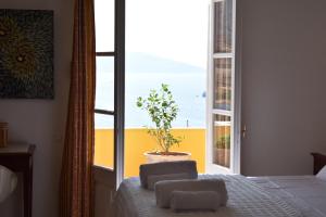 Dormitorio con ventana y cama con maceta en Chez Le Goff, en Hydra