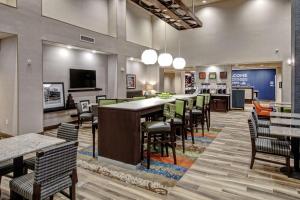 un ristorante con un lungo bar con sedie e tavoli di Hampton Inn & Suites Culpeper a Culpeper