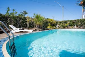 een zwembad met een stoel en palmbomen bij The Marco Polo in Mackay