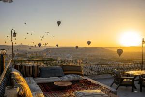 ein Wohnzimmer mit einem Sofa und Heißluftballons in der Unterkunft Ages in Cappadocia in Uchisar