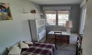 una camera con letto, scrivania e tavolo di Appartement avec Terrasse à Puteaux 92 a Puteaux