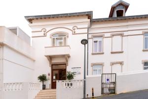 un edificio blanco con una escalera delante en Residencial Real Guest House, en Sintra