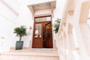 una puerta de madera en un edificio blanco con una maceta en Residencial Real Guest House, en Sintra