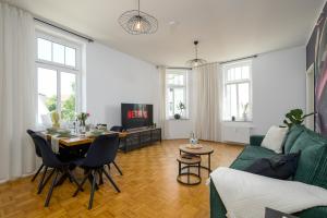 een woonkamer met een groene bank en een tafel bij LE Vacation 3-Room-Apartment 67qm, Küche, Netflix, Free-TV in Schkeuditz