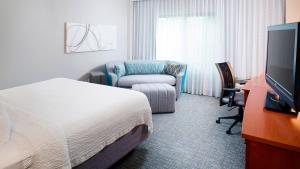 een hotelkamer met een bed en een stoel bij Courtyard by Marriott Roanoke Airport in Roanoke