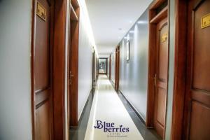 een hal van een gebouw met een bord met blauwe voordelen bij Blue Berries Hotel in Entebbe