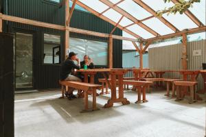 un homme et une femme assis à une table de pique-nique dans l'établissement Camping Yellow Plum, à Puerto Natales