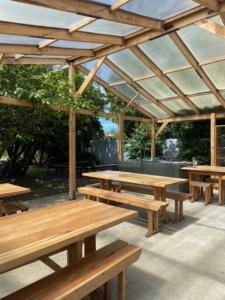 - un groupe de tables de pique-nique en bois sous un pavillon dans l'établissement Camping Yellow Plum, à Puerto Natales