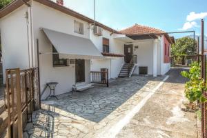 een wit huis met een veranda en een trap bij SOCRATES Ethnic and traditional Home in Kalabaka