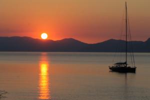 una barca a vela in acqua al tramonto di Maeiz Skopelos a Skopelos Town