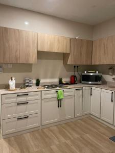 cocina con armarios blancos y microondas en شقة عائلية خاصة مفروشة في الخبر 1, en Al Khobar