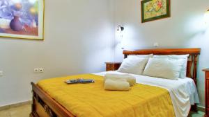 a bedroom with a large bed with a yellow blanket at Villa Vivere in Corfu Town