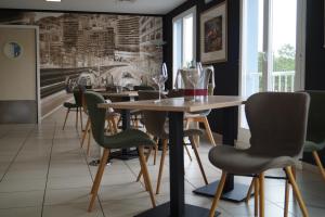 een eetkamer met een tafel en stoelen bij Hotel-Restaurant Stand'Inn in Foetz