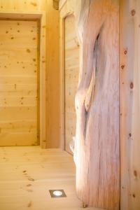 una pared de madera en una cabaña de madera con un gran tronco de árbol en Hotel Pradell, en Ortisei