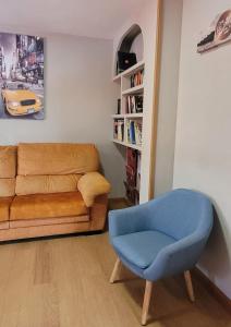 a living room with a couch and a blue chair at www apartamentovaldivia es Parking incluido in León