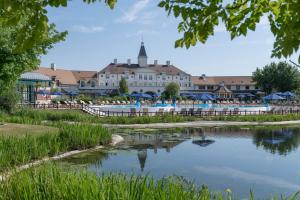 ośrodek ze stawem przed budynkiem w obiekcie Marriott's Village d'Ile-de-France w mieście Bailly-Romainvilliers