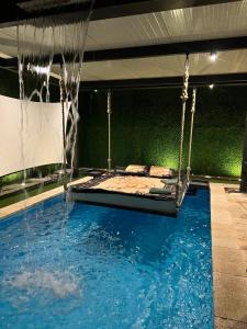 a swimming pool with a swing in the middle at Spa Lux Apatin in Apatin