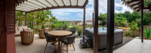 d'une terrasse avec une table et une baignoire. dans l'établissement La Suite Villa, à Les Trois-Îlets