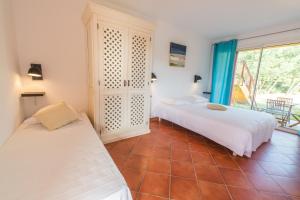 - une chambre avec 2 lits et une fenêtre dans l'établissement Casa Vecchia rooms + apartments, à Calvi