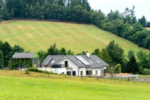 une maison avec des panneaux solaires sur le toit d'un champ dans l'établissement Ubytování v soukromí v Šachu, à Volfířov