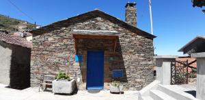 a small stone building with a blue door at Casa do Loureiro in Arganil