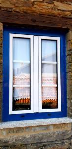 two windows in a blue and white wall at Casa do Loureiro in Arganil