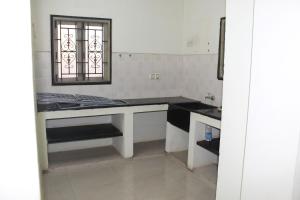 eine Küche mit einem Tisch und einem Fenster in der Unterkunft Centaurus Homestay near Trichy Airport in Tiruchchirāppalli