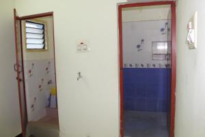 ein Badezimmer mit einer Dusche mit blauer Wand in der Unterkunft Centaurus Homestay near Trichy Airport in Tiruchchirāppalli