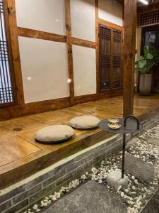 Duas almofadas em cima de um alpendre de madeira em Bow Hanok House em Gangneung