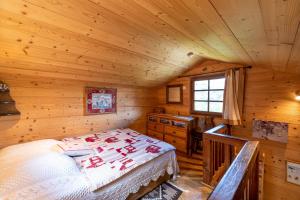 - une chambre avec un lit dans une cabane en bois dans l'établissement Chalet du Brey - Avec terrasse et jardin, à Saint-Gervais-les-Bains