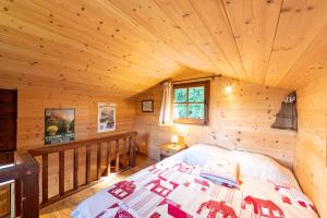 - une chambre dans une cabane en rondins avec un lit dans l'établissement Chalet du Brey - Avec terrasse et jardin, à Saint-Gervais-les-Bains